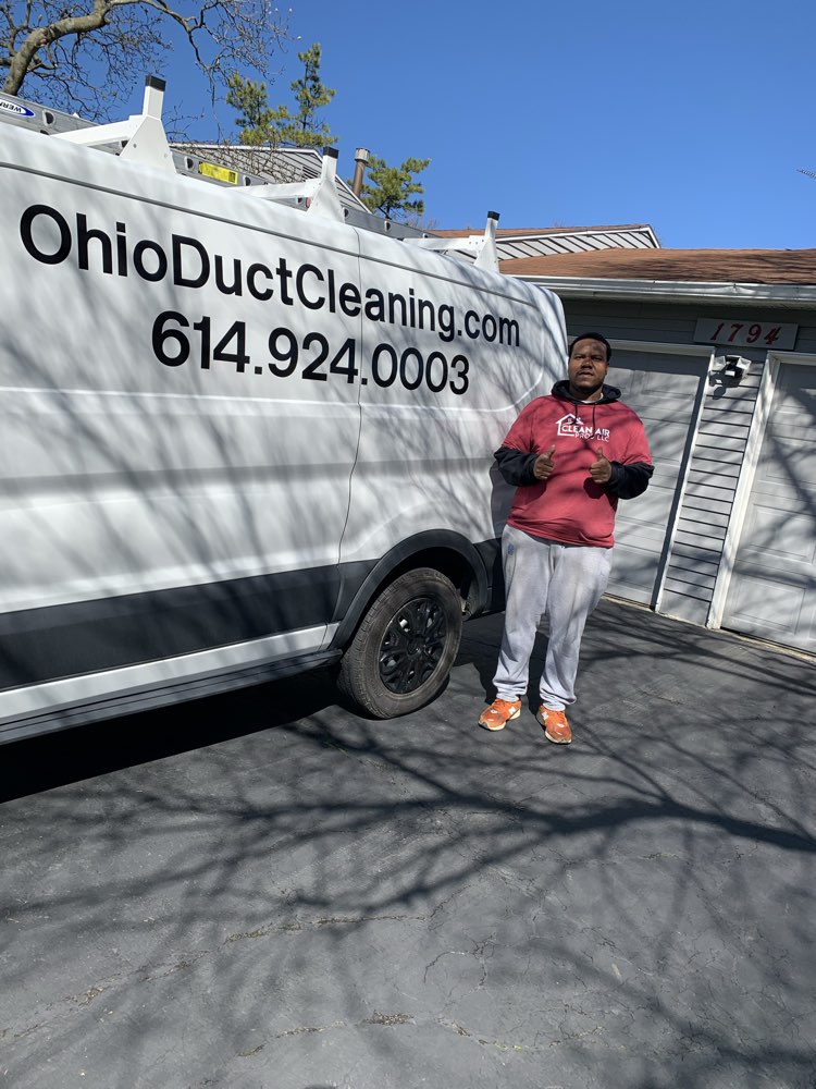 Clean Air Pros technician gives thumbs up by branded service van parked at a Hilliard Ohio home — ready to begin residential air duct cleaning