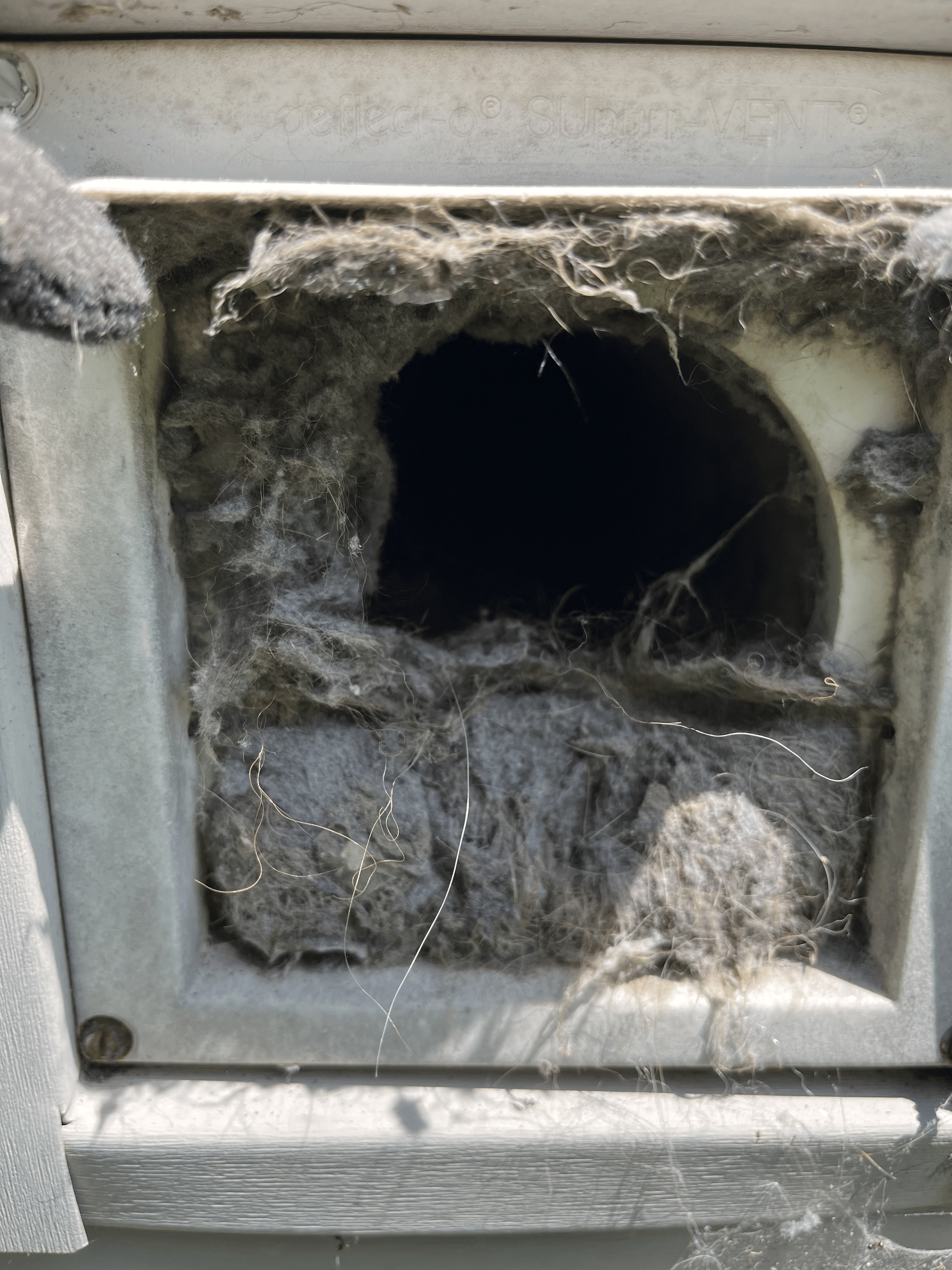 Completely clogged dryer vent showing solid lint blockage at dryer outlet — Columbus Ohio