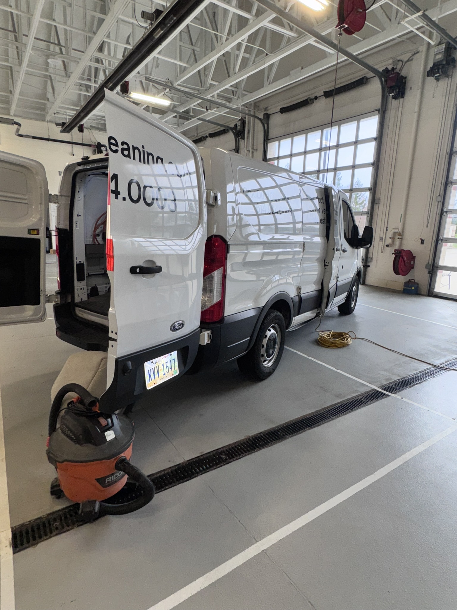 Clean Air Pros duct cleaning inside Powell Ohio fire station — extraction hose going into ceiling with Dalmatian statue visible
