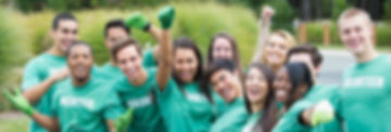 diverse group of young people wearing volunteer shirts, happy with fists in the air