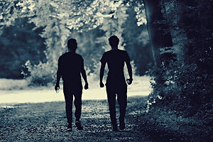 The silhouette of two men walking along a path