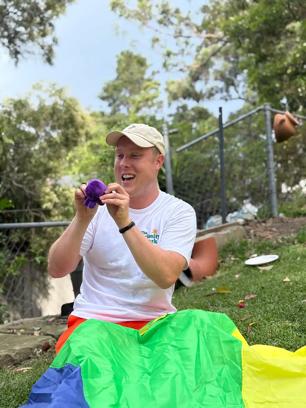 Kids entertainer using puppets and playful props during an outdoor birthday party activity.