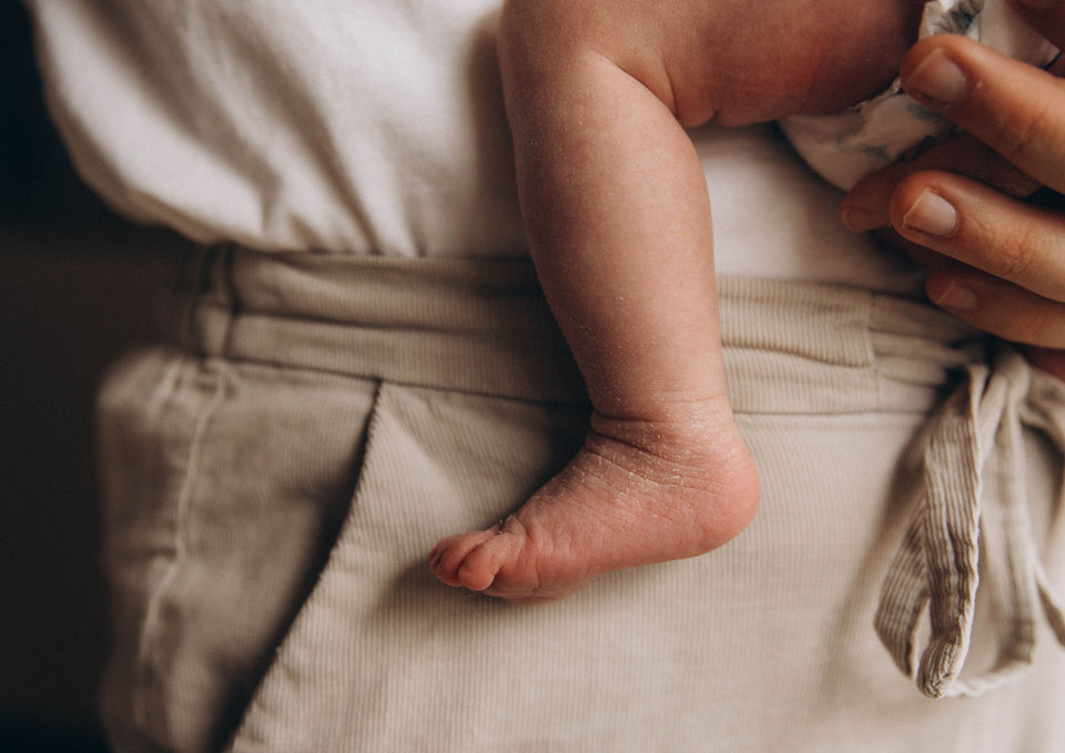 Petit pied de bébé dans les bras de son père