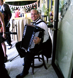 Pablo De Vincenzo smiling posing with an accordion.