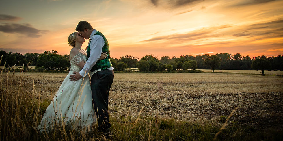 Bride and Groom kissing by a sunset lit field, Brasteds, Norwich