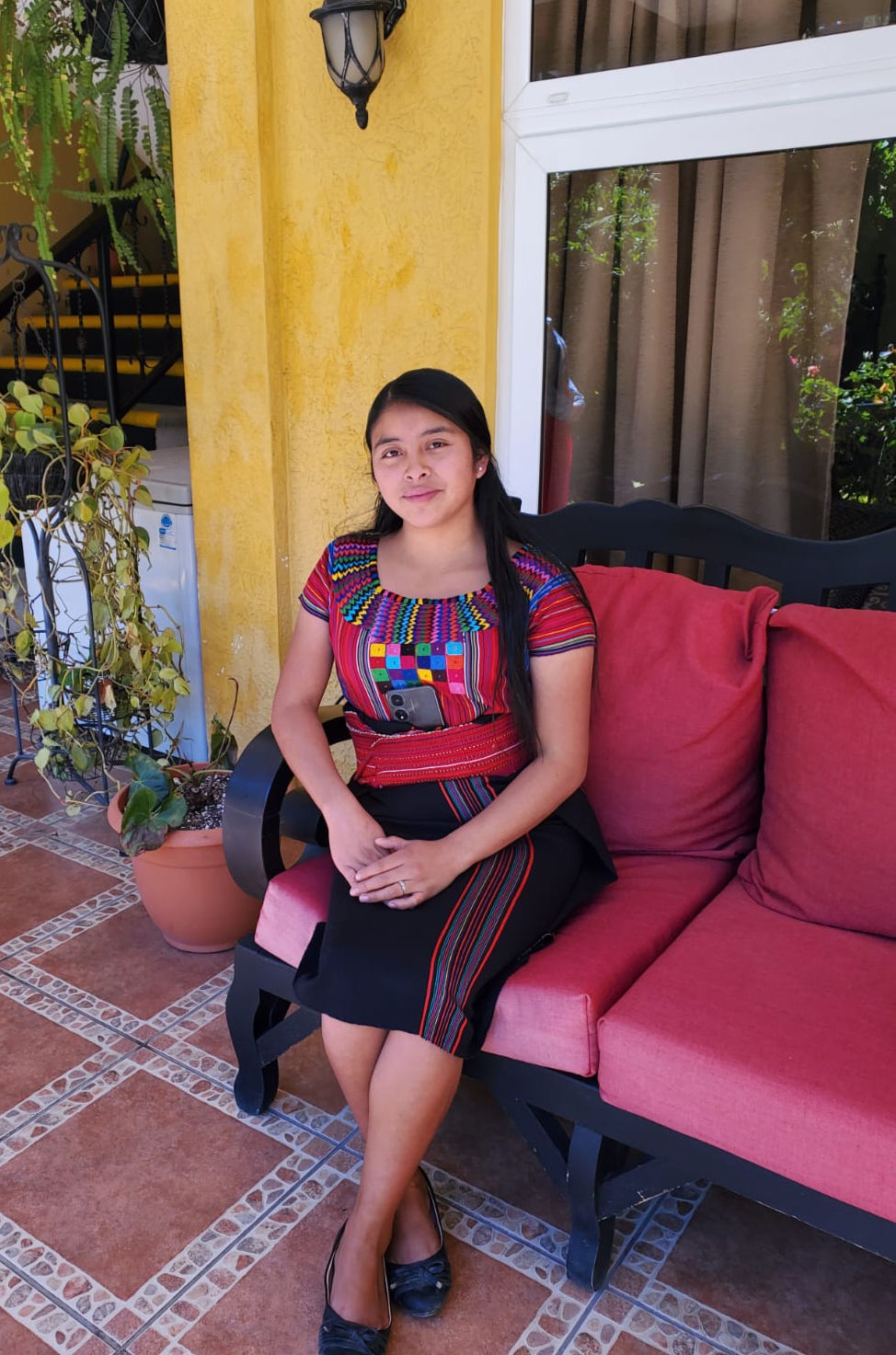 A young woman sits on a patio