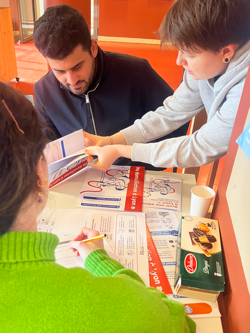 Animatrice présentant un livret d’information à deux participants pendant une séance de test.
