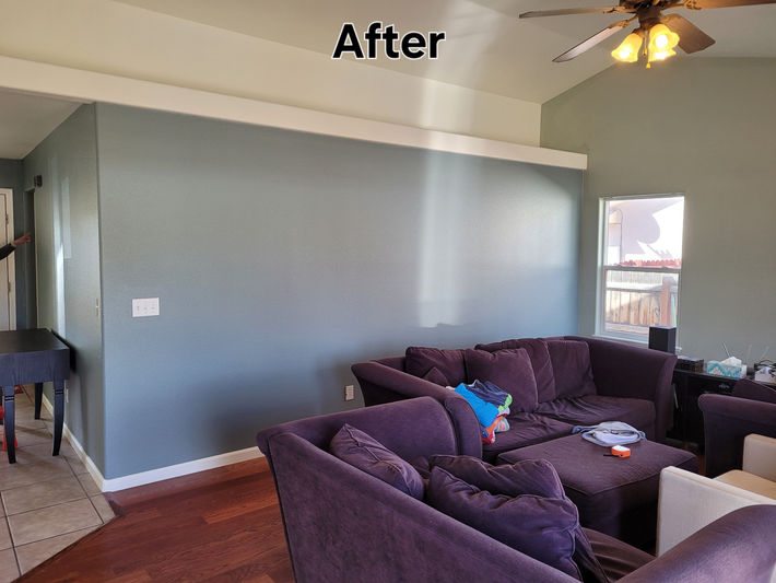 After photo of a professionally painted open-concept living room and hallway with light neutral walls and white trim in a Grand Junction home by Prime Painting Experts.