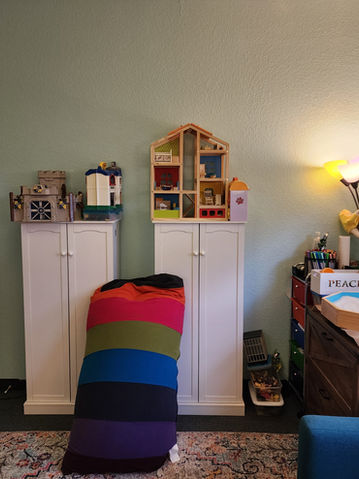 Playful therapy room with toys and rainbow blanket