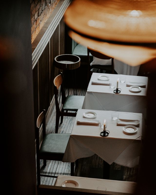 The image shows an elegant gourmet dish served inside a bistro restaurant interior.