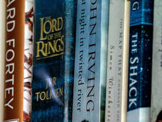 Stack of the world's best-selling books including classic novels, fantasy epics, and personal development titles arranged on a bookshelf.