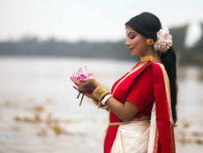 Bengali woman wearing a traditional red and white saree during Durga Puja celebrations