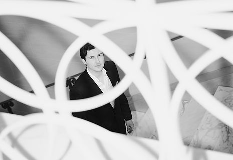 Artistic shot of a man through a wrought iron railing
