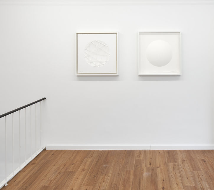 White minimalist paper art on white gallery wall with wooden floors at Schlieder Contemporary art gallery in Frankfurt