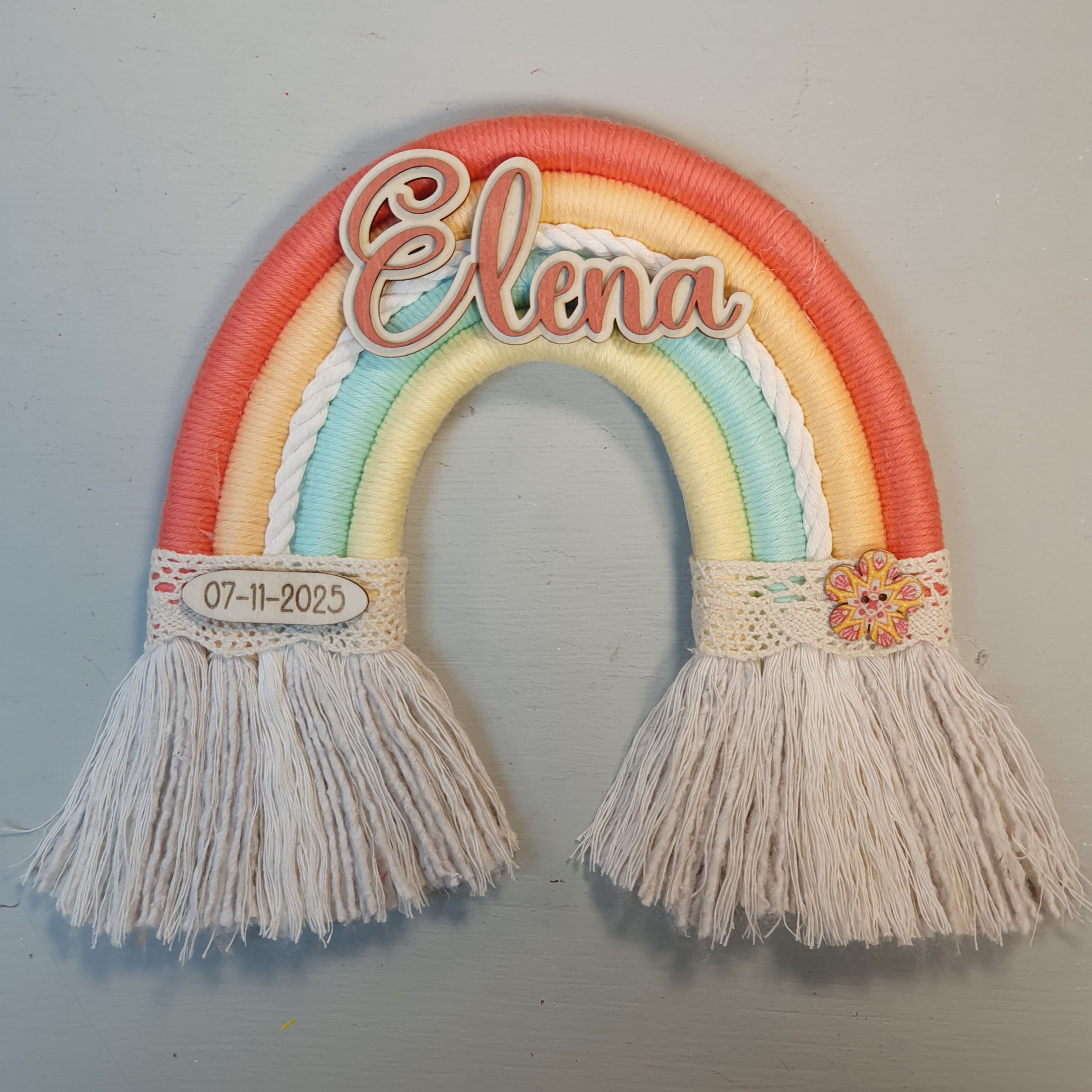 Handgemaakt gepersonaliseerd regenboogje met naam, zachte kleuren en decoratieve details