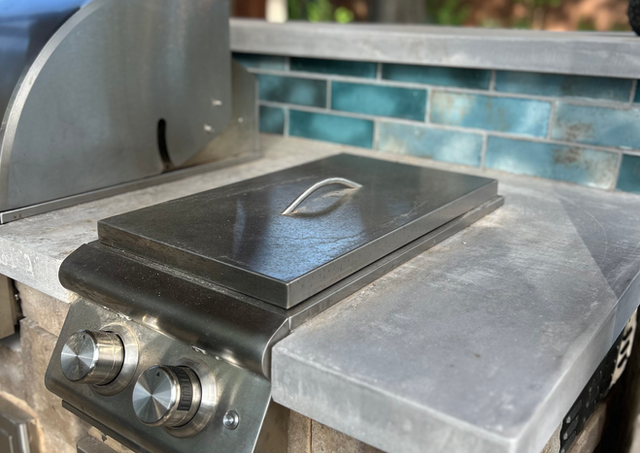 Custom outdoor kitchen with Belgard wall system, concrete countertop, and tile accents in San Antonio.