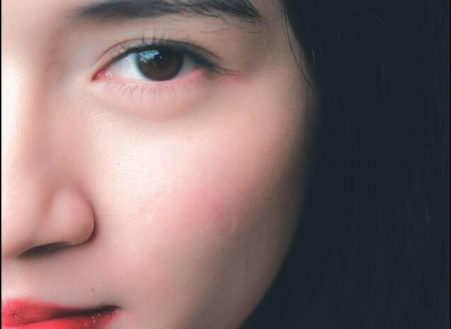 An image featuring a woman with prominent cheekbones and voluminous under-eye area. Her cheekbones are well-defined, adding structure to her face. The under-eye area appears full and youthful, with a slight shadow that adds depth to her eyes. This combination enhances her facial features, giving her a captivating and alluring look