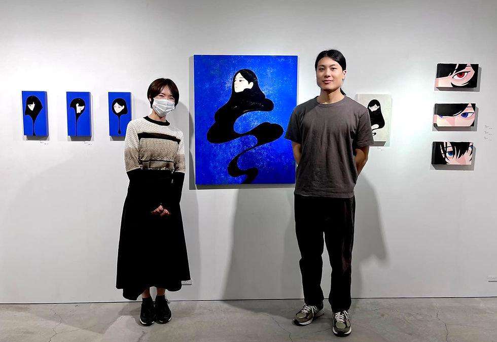 山中智郎さんの個展「たおやか」で作品を挟んで並ぶ額装家多喜博子とイラストレーター山中智郎さん