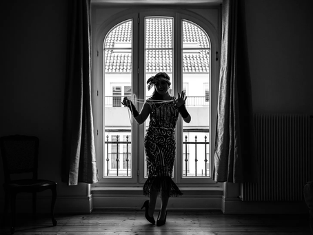 A flapper girl in front of a window.