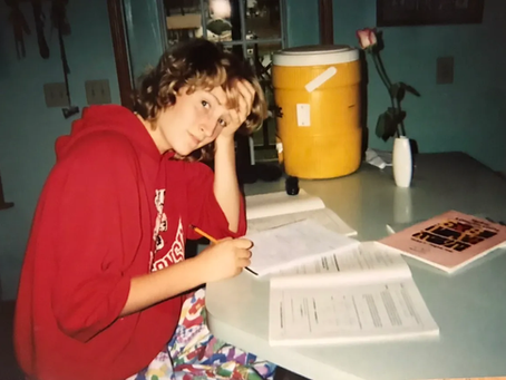 A girl doing homework in the kitchen.