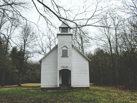 A white church in the woods.