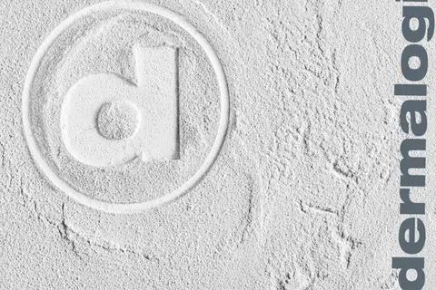 Embossed Dermalogica logo with a lowercase d in a circle on a textured gray surface, minimalist white and gray design.