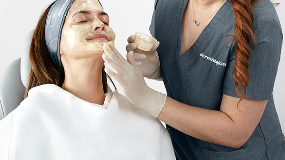Aesthetician applies cream to woman's face in a clinic. Text promotes Dermalogica's new Melanopro Peel System for hyperpigmentation.