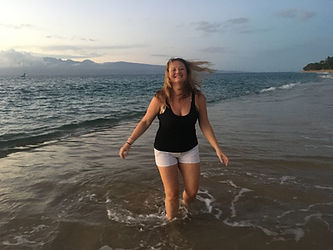 Photo of Heather Michele the owner of Somatic Pilates smiling and running on the beach in Hawaii