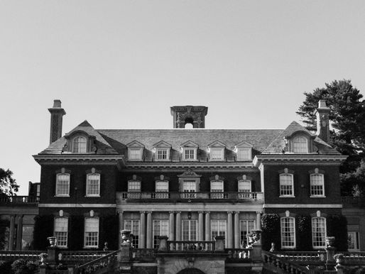 Old Westbury Gardens 夏日花园中的情侣订婚写真，背景为历史庄园建筑与精致花园