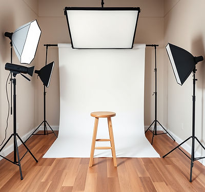 a small photography studio with neutral walls and oak floor. white large backdrop. 2 large