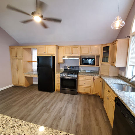Large kitchen island, custom cabinets, black appliances