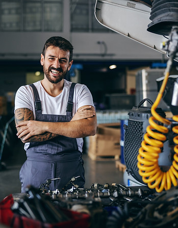 smiling-happy-bearded-tattooed-worker-overalls-standing-truck-with-arms-crossed.jpg