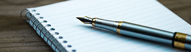 A pen resting on an open notebook containing a handwritten checklist of new home requirements and dream features.