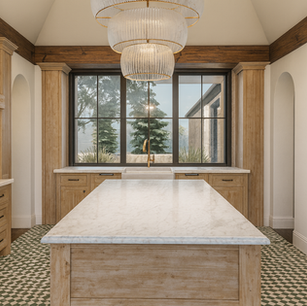 Symmetrical luxury kitchen with large center island, patterned tile floor, wood columns, and statement chandelier—classic custom kitchen.