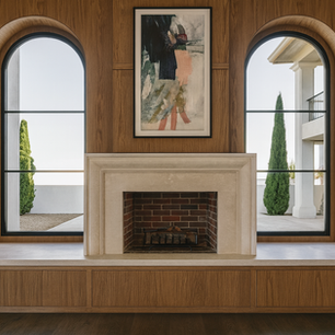Wood-paneled fireplace wall with limestone mantel, brick firebox, and twin arched windows—transitional luxury fireplace focal point.