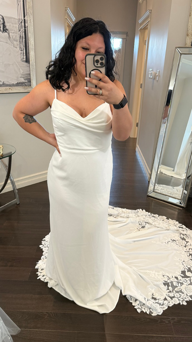 Bride trying on wedding dress with ivory lace and sequins over champagne tulle back, spaghetti straps, buttons to end of illusion train.