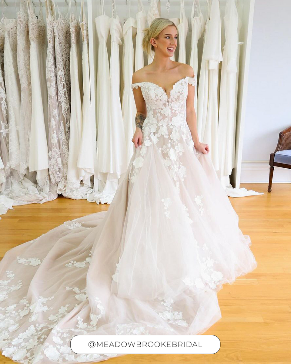 Woman wearing an Eddy K ballgown with ivory lace over champagne tulle, 3D appliqués
