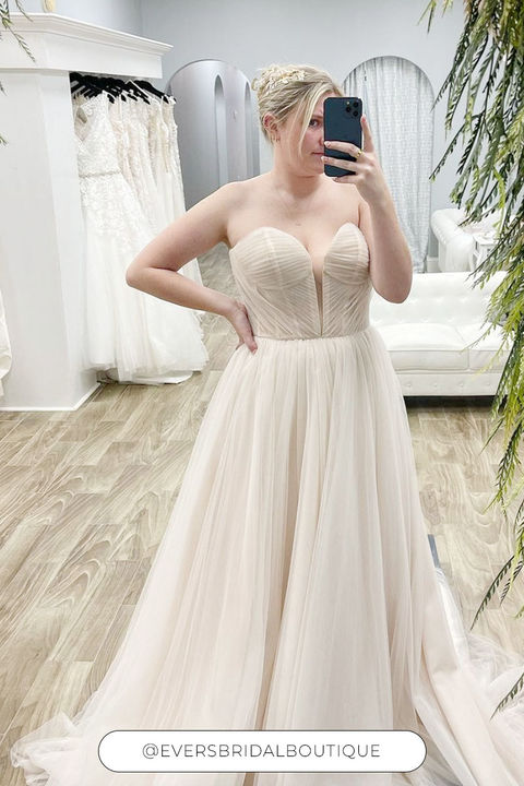 Woman wearing strapless ballgown with layered champagne tulle
