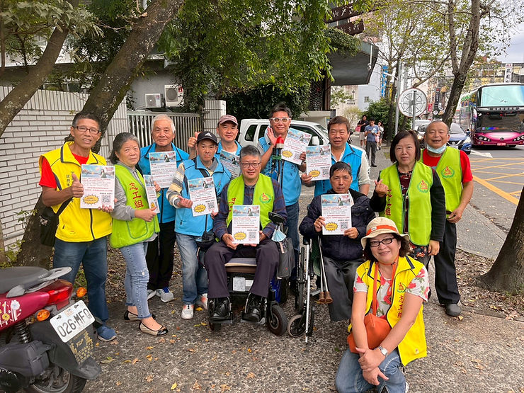 宜蘭縣肢體障礙者協會志工團隊於建築前再次合影,展示公益票選宣傳單,持續向社區倡議支持身障者服務。