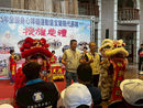 在115年全國身心障礙運動會宜蘭縣代表隊授旗典禮的舞台上,宜蘭縣議會副議長陳漢鍾(中左)與地方長官及貴賓身穿米黃色背心,面帶笑容對著鏡頭豎起大拇指比讚。他們兩側分別站著紅色與黃色的威武舞獅,黃色舞獅前掛有「祥獅獻瑞」的紅底金字卷軸,後方大鼓寫著「大洲國小龍獅隊」。舞台背景為寫有「授旗典禮」與「拚出宜蘭好生活」的大型藍色主題看板,前景則為前來參與和觀禮的民眾與來賓背影。