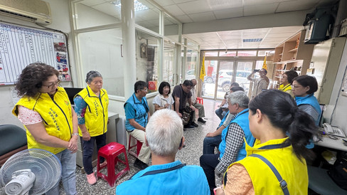 宜蘭縣志願服務協會成員與在地志工在辦公室進行座談，志工低頭翻閱資料紀錄，氣氛專注認真。