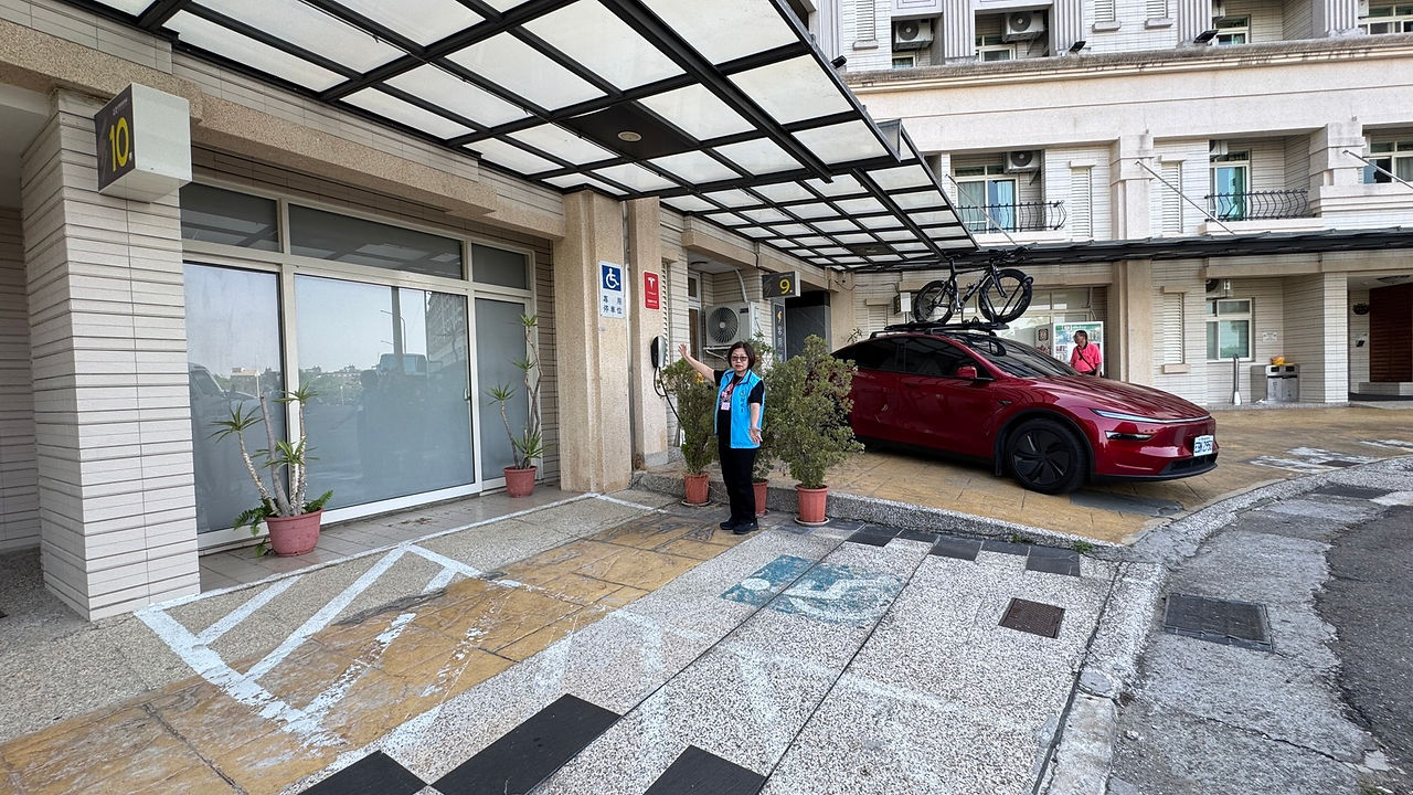 協會隨隊訪視員站在無障礙專用停車位手指著牆上無障礙標誌進行展示。