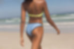 young-african-american-woman-green-bikini-walking-beach (1).jpg
