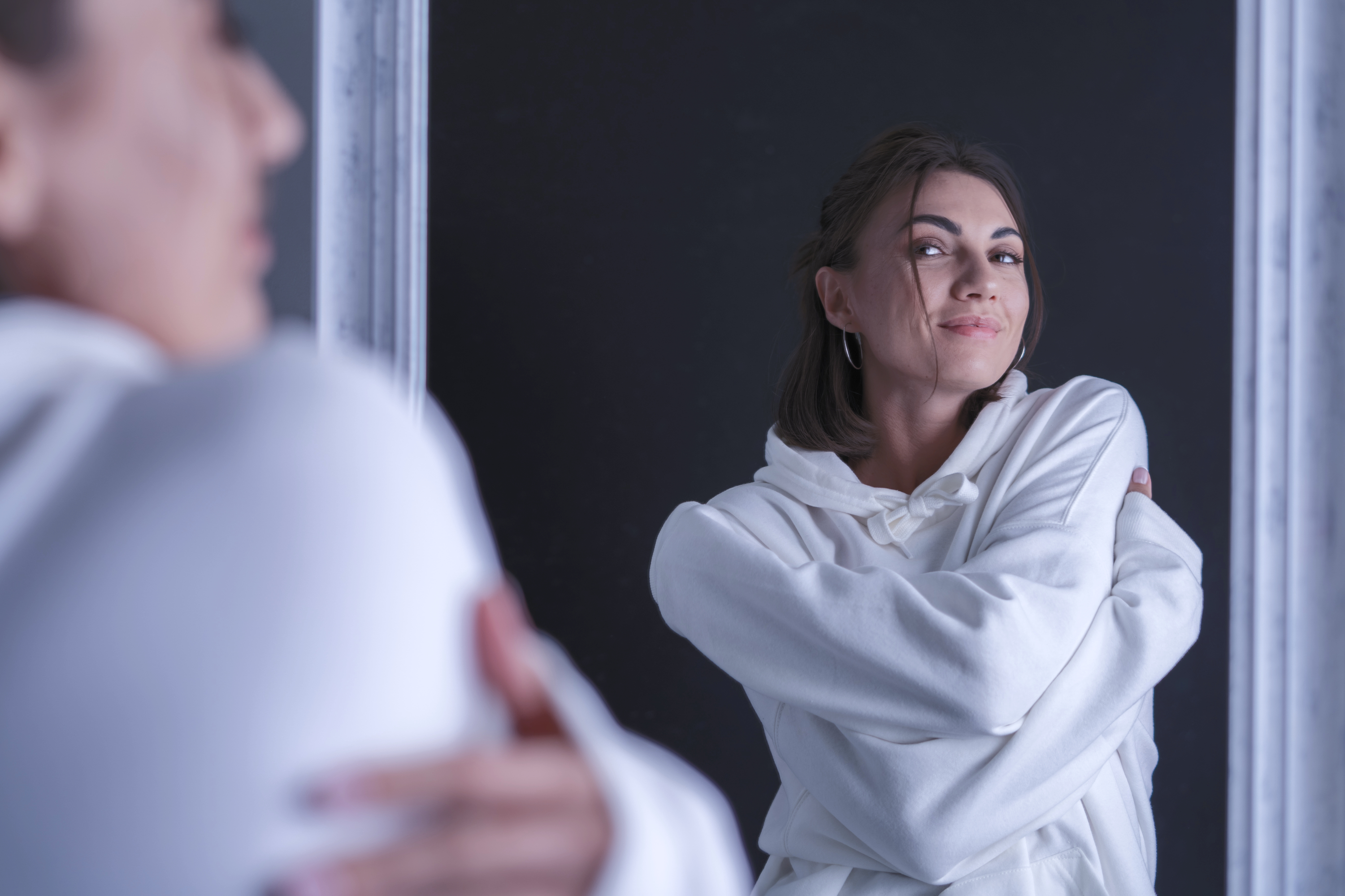 young-woman-white-hoodie-posing-mirror.jpg