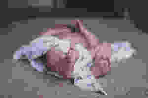 baby lying on brown surface