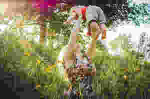 woman carrying baby near grass