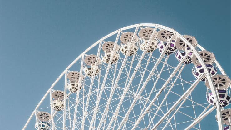 White Ferris wheel in front of blue skies
