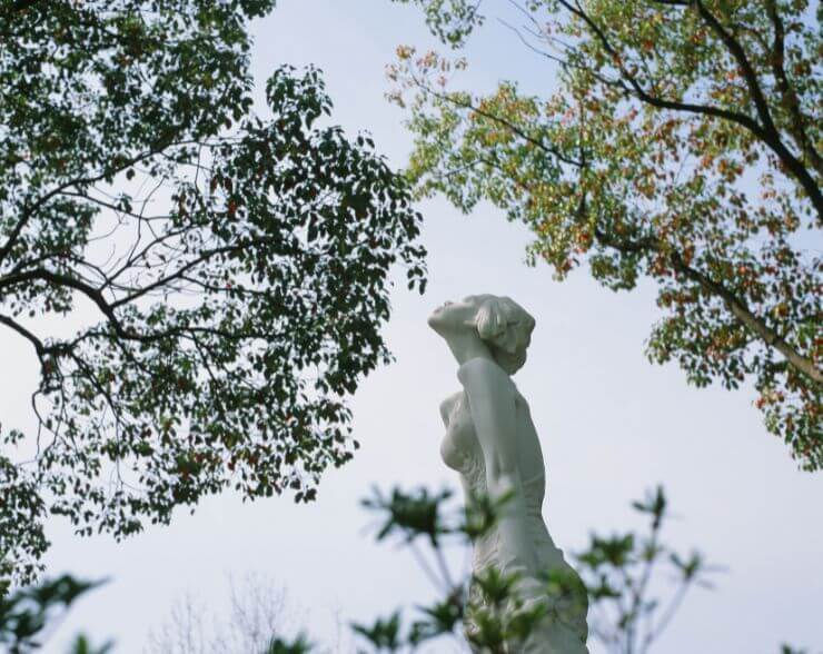 A statue of a woman amongst the trees