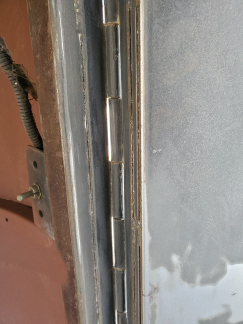 Close up on service side door hinge before priming