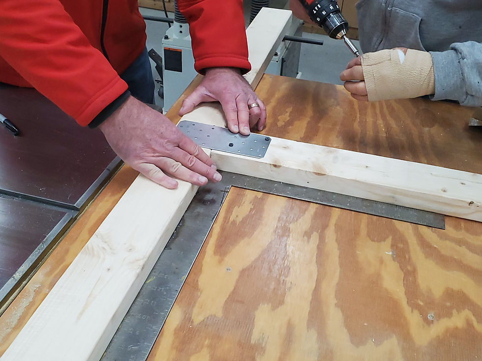 Screwing together the service window's wooden frame